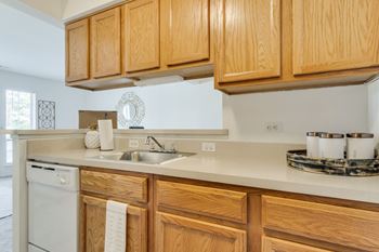 A kitchen with wooden cabinets and a white dishwasher